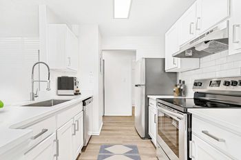 a kitchen with white cabinets and stainless steel appliances at Bridges at Mallard Creek Apartment Homes, North Carolina, 28269